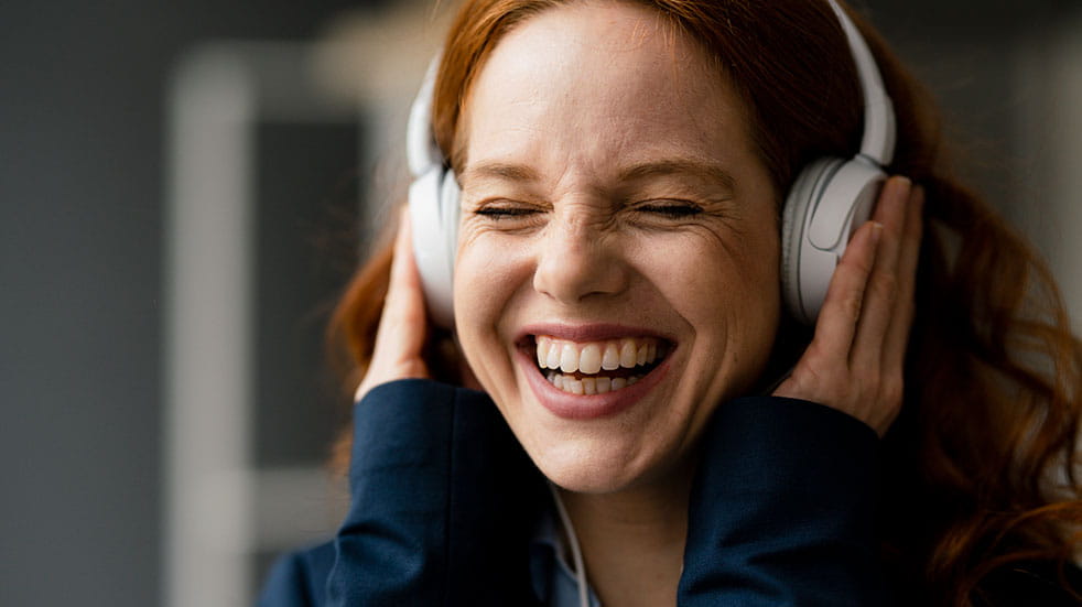 Boost your mental health woman wearing headphones laughing